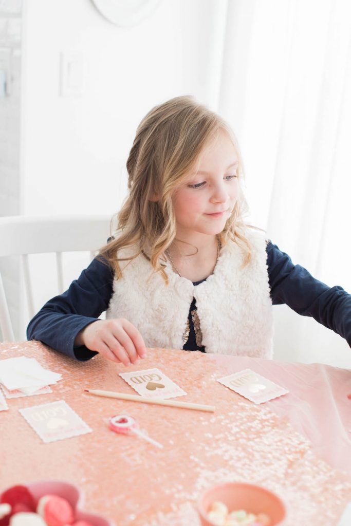 Little girl writing valentines day cards