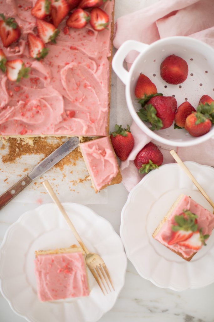 top view of cake cut bowl of strawberries