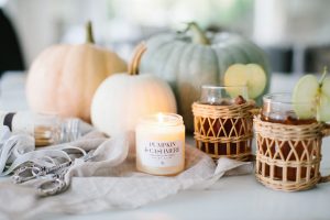 Pumpkins with candle burning and hot apple cider