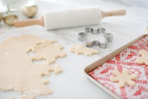 rolling out snowflake cookies