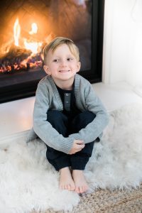 little boy sitting by fire
