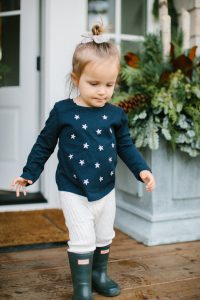 little girl wth stars on shirt walking