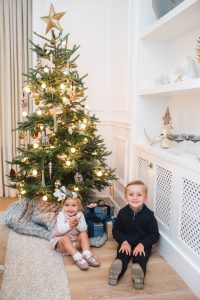 little boy and girl sitting in front of tree