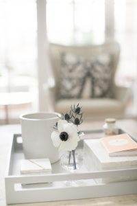 coffe table with candel and bud vase chair in background