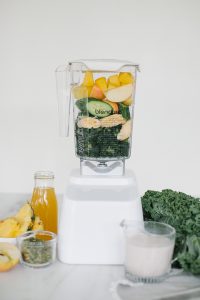 blender with tropical ingredients and kale