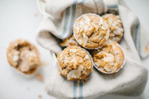 close up of banana muffins in tin with a linen napkin