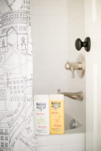 body wash on side of tub with Paris shower curtain