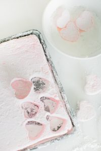 heart shaped marshmallows in a bowl and on baking sheet
