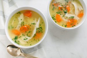 bowls of soup with parsley garnish spoon on side