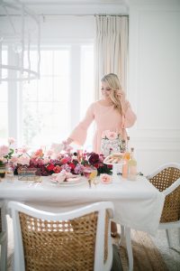 women in pink dress setting beautiful valentines table