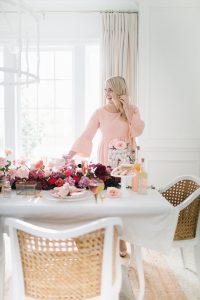 women in pink dress setting beautiful valentines table