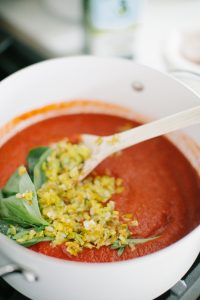 Pot with fresh tomato sauce, basil and leeks