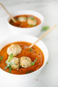 Tomato bisque soup with turkey meatballs and basil garnish