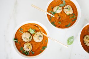 Tomato bique soup in bowls garnished with turkey meatballs