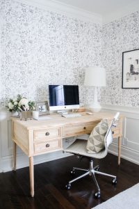 office space with black and white wallpaper and light wood desk