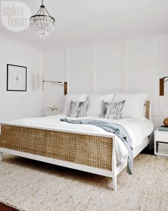 White bedroom with chandelier and large white bed