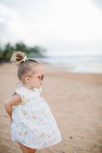 little girl on beach in cute dress and sunglasses