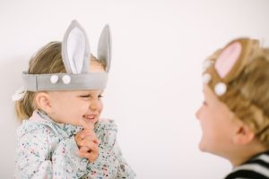 cute little girl in bunny ears looking at brother