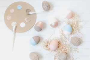 flat lay paper painted easter eggs and raffia