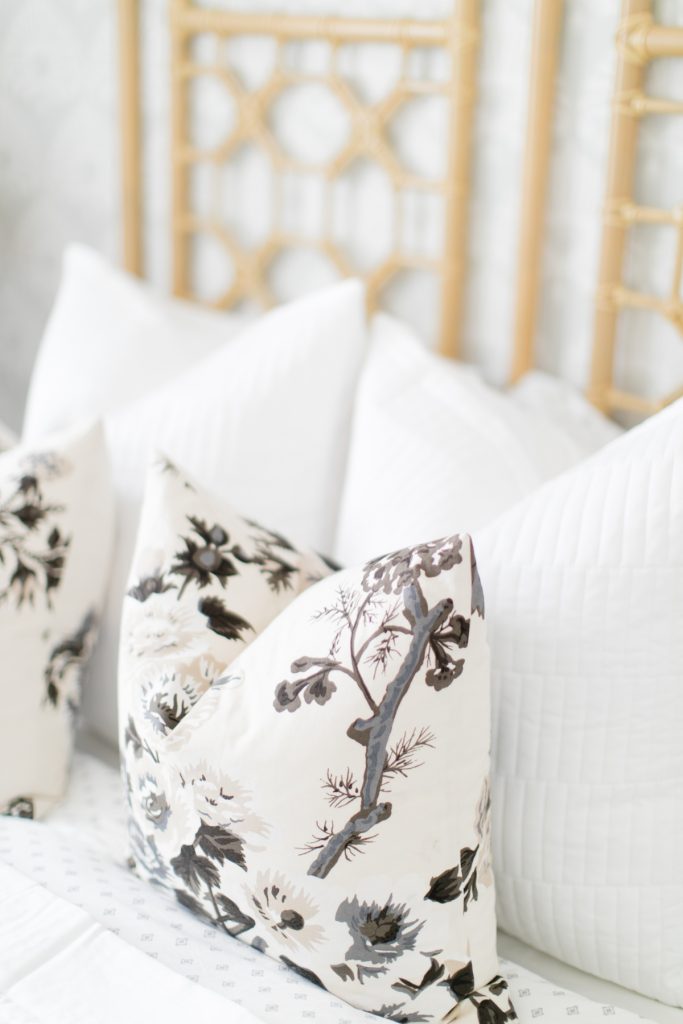 light grey and black floral pillows on bed