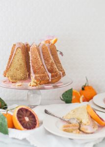 bundt cake on glass cake stand, citrus fruit