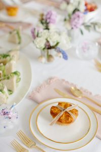 gold rimmed plates and flatware with blush napkin