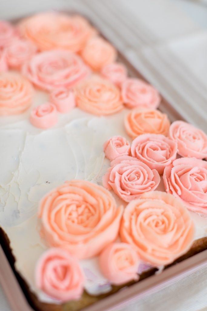 butter cream roses in pink and blush on sheet cake