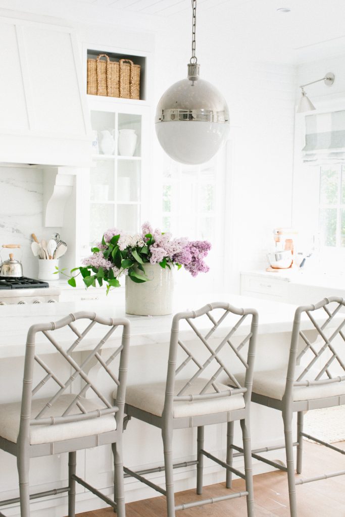 white kitchen with lilacs on counter