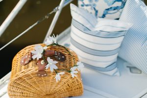 picnic basket on boat with stripped pillows