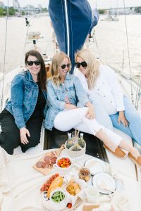 women on sailboat with charcuterie platter