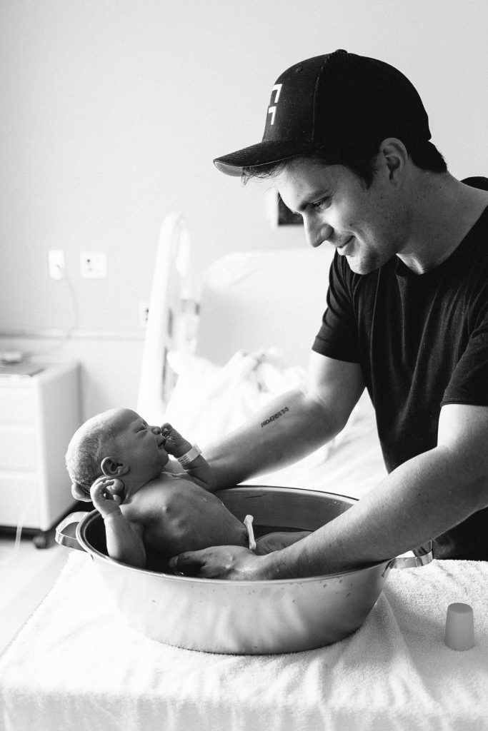 dad bathing newborn