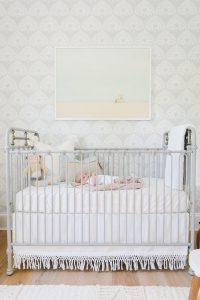newborn in metal crib in coastal nursery
