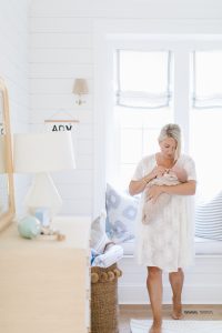 mom waking with newborn in nursery