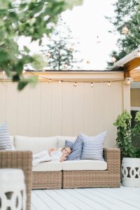 little girl on rattan outdoor couch