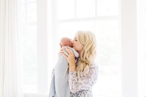 mom kissing newborn