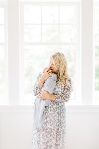 mom in blue and white maxi dress holding newborn