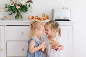 two cute little girls with toast in their hands