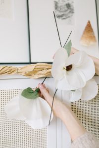attaching magnolia flowers to paper garland