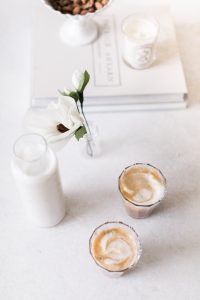 Almond Cashew Mylk Coffee Creamer two glasses of latte with milk and a flower