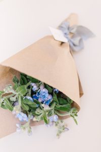 blue flowers wrapped in brown paper