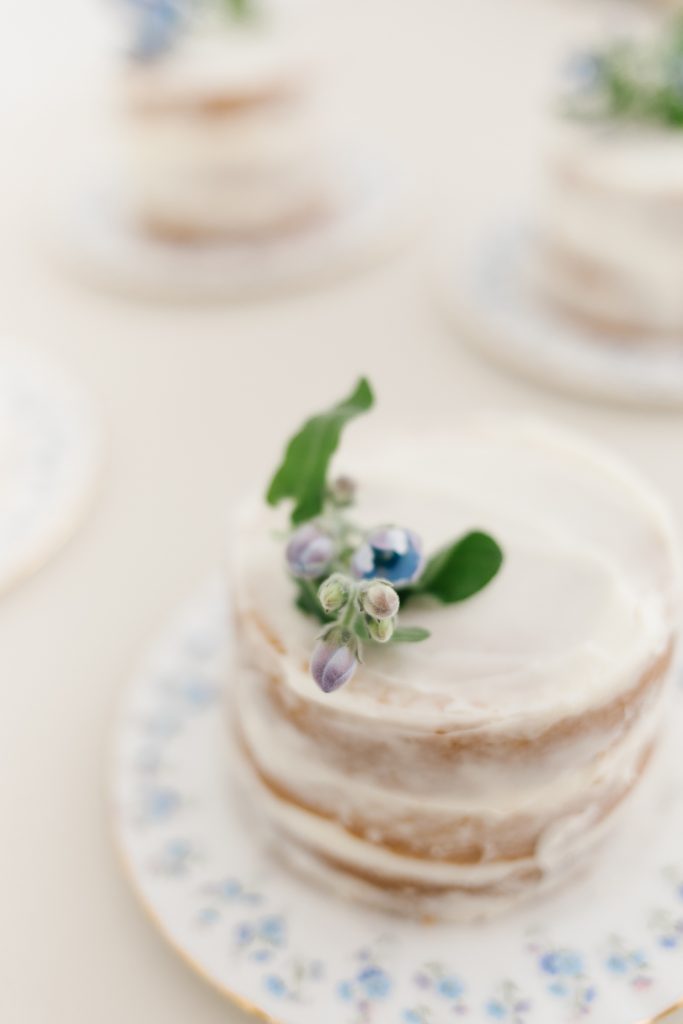 mini naked iced vanilla cake with blue flowers