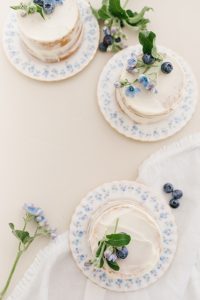 three mini vanilla cakes with blooms and blueberries