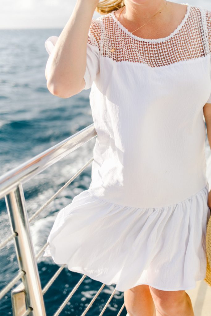white drop waist dress with eyelet detail women on boat