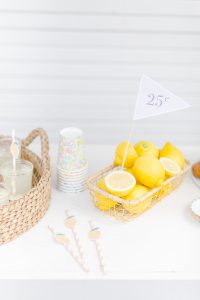 tabletop with 25 cent flag in a basket of lemons