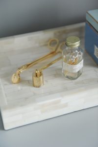 bottle of matches and candle snuffer on a tray