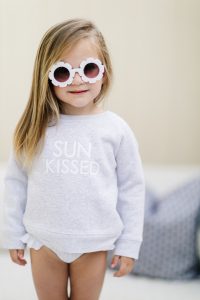 young blonde girl wearing daisy sunglasses and Sun Kissed crew neck sweater