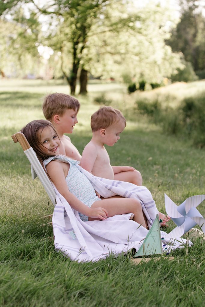 three children sitting on the lawn