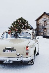 Vintage Car with Christmas Tree on Roof in Snow